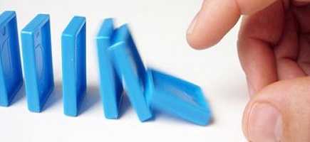 A hand pushes blue dominoes.
